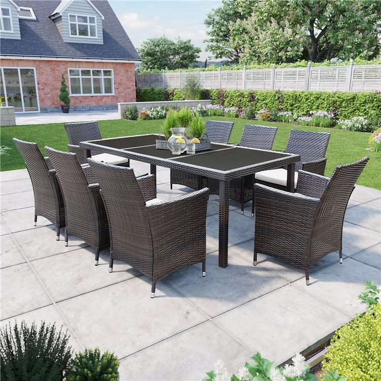 Siena 8 Seater Rectangular Rattan Dining Set in a large grassy garden with a house in the background.